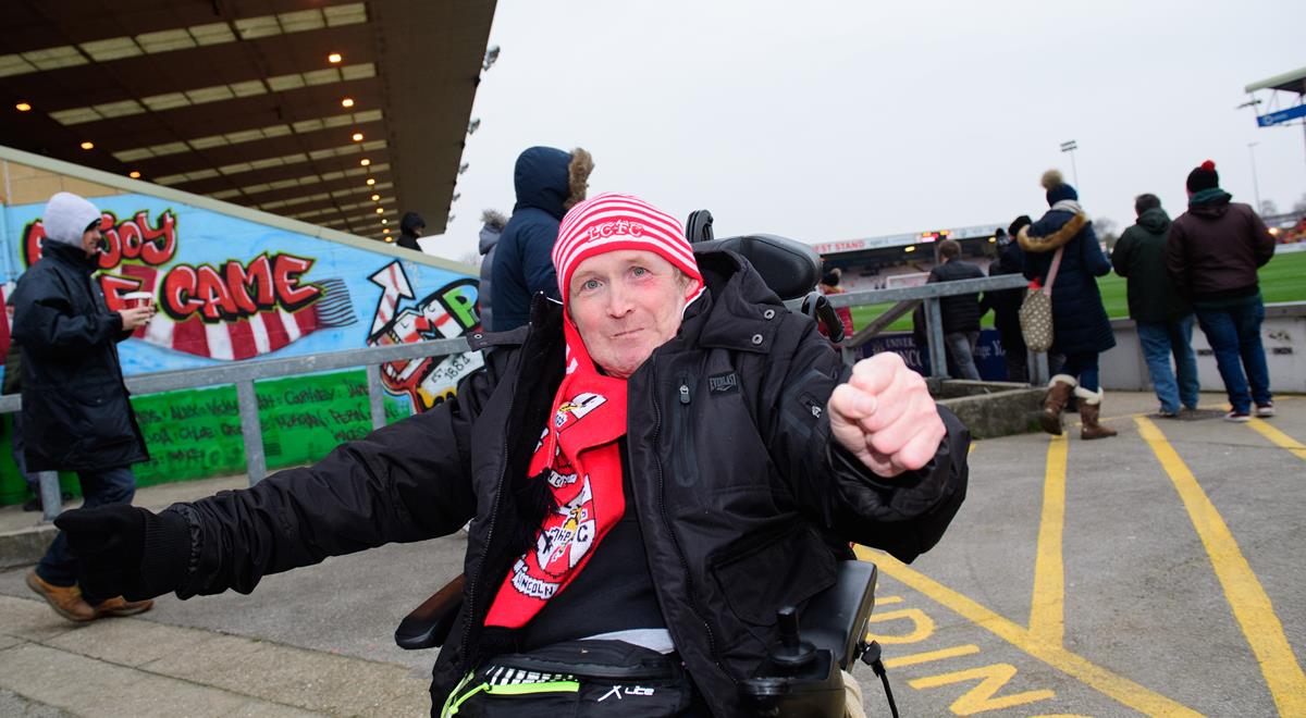 A man in a wheelchair, at a football game