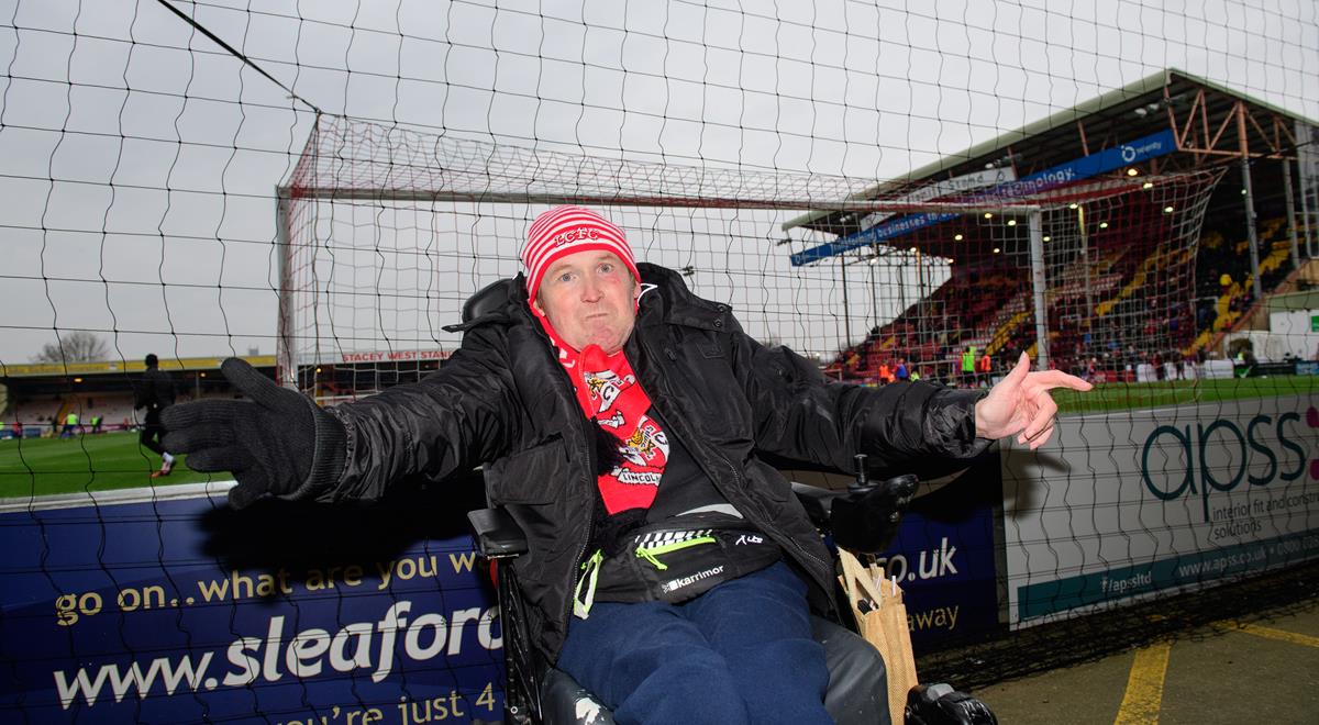 A man in a wheelchair, at a football game