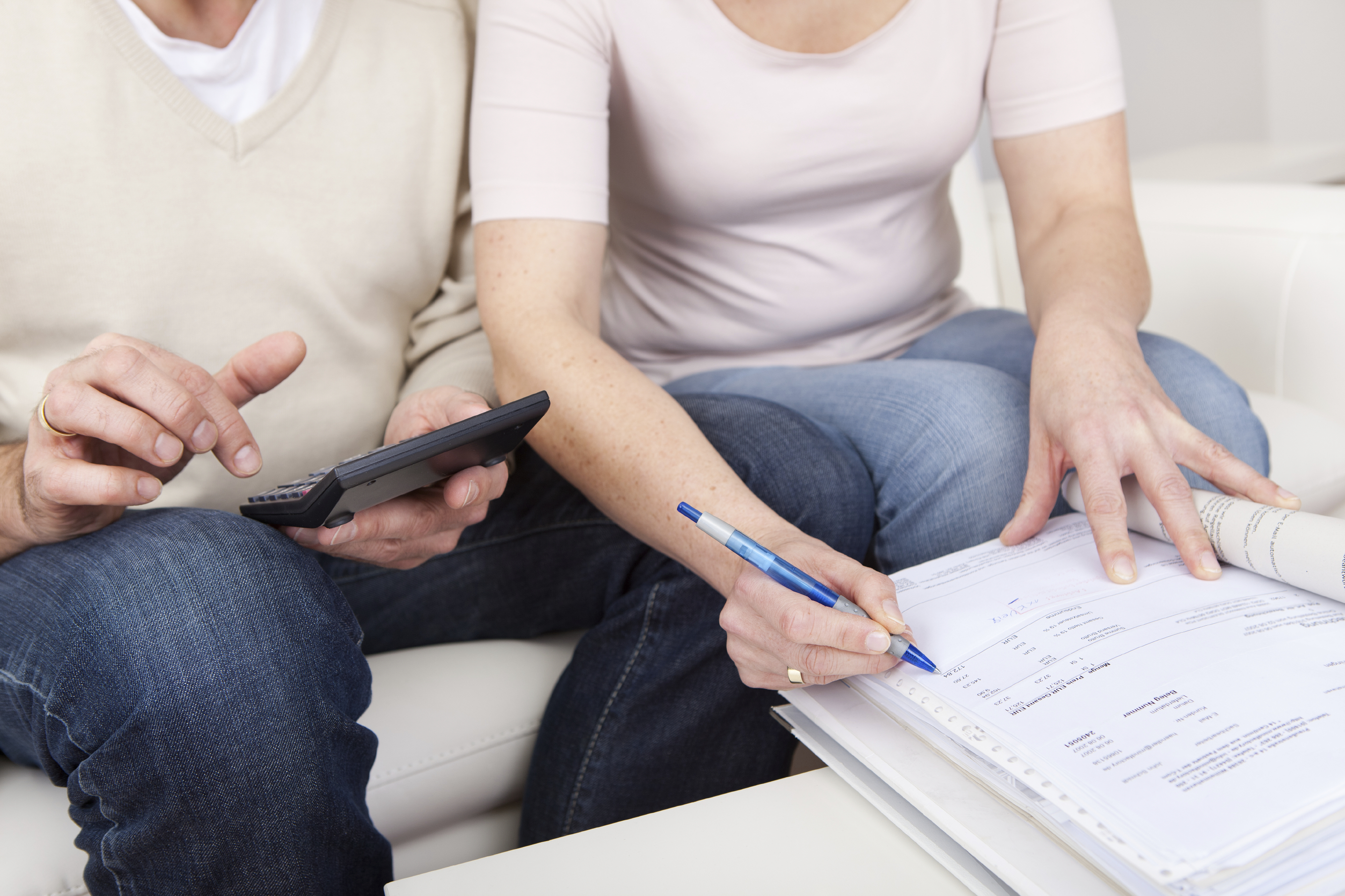 man and lady looking at documents with calculator