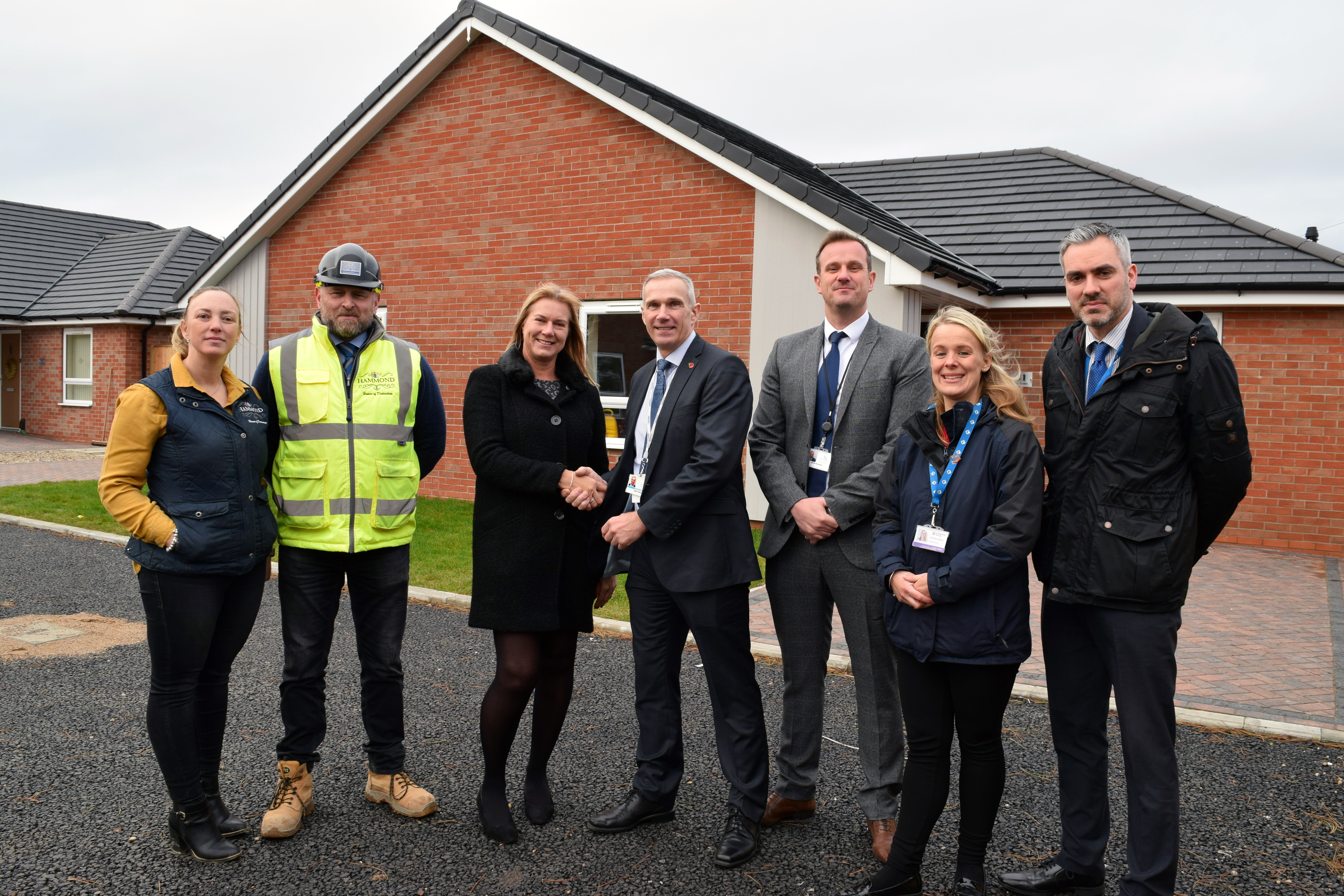 Longhurst Group Project Manager Tracey Pearson, third from left, shakes hands with Councillor John Fenty, Deputy Leader of North East Lincolnshire Council and Portfolio Holder for Housing, Regeneration and Skills. Looking on are, from left, Debbie and Nick Hammond of Hammond Homes, Mark Nearney, Assistant Director of Housing at North East Lincolnshire Council, Longhurst Group Housing Officer Gemma Nelson and Ian Penn, Longhurst Group's Head of Development.
