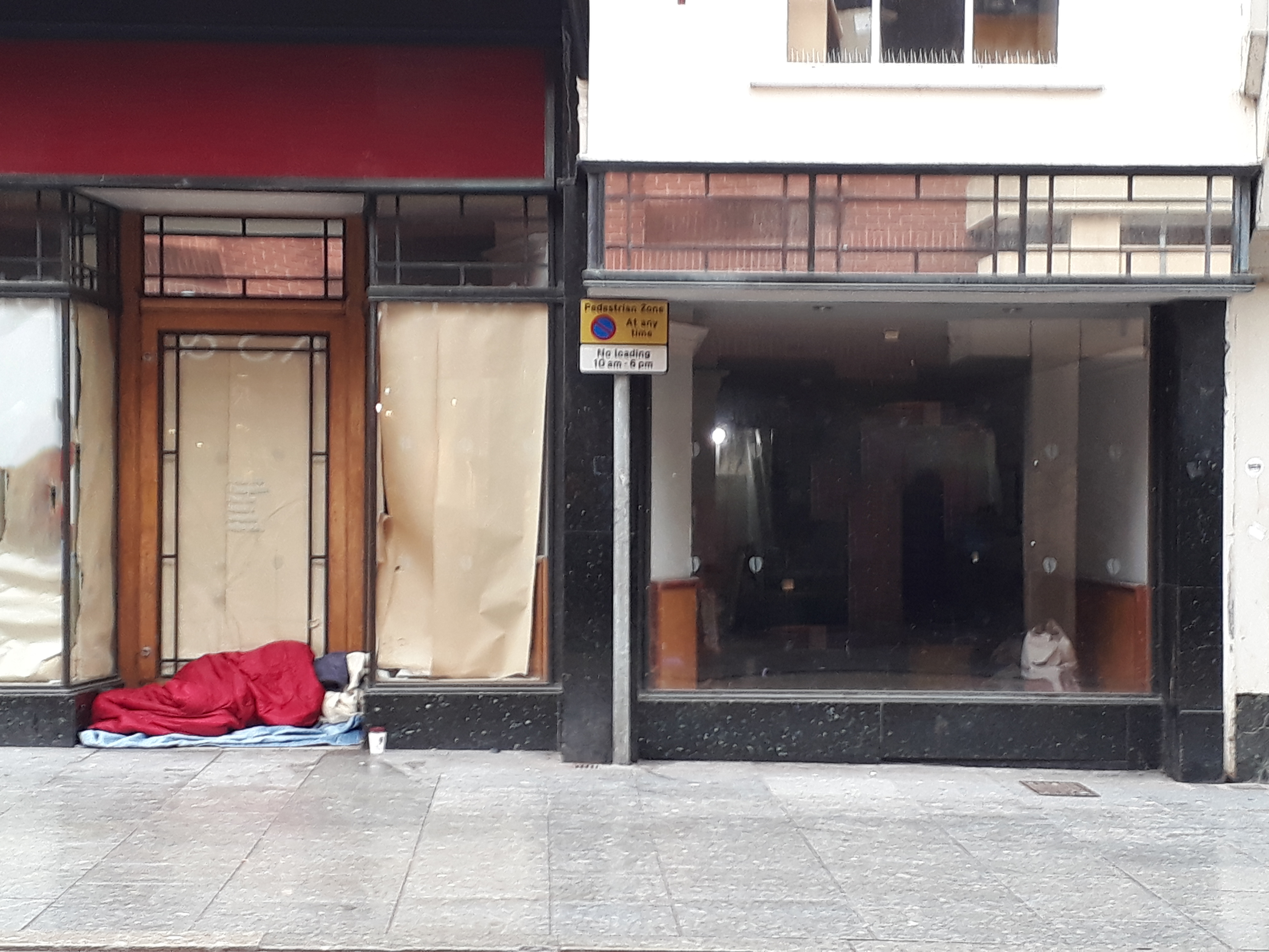 Homeless man in shop doorway