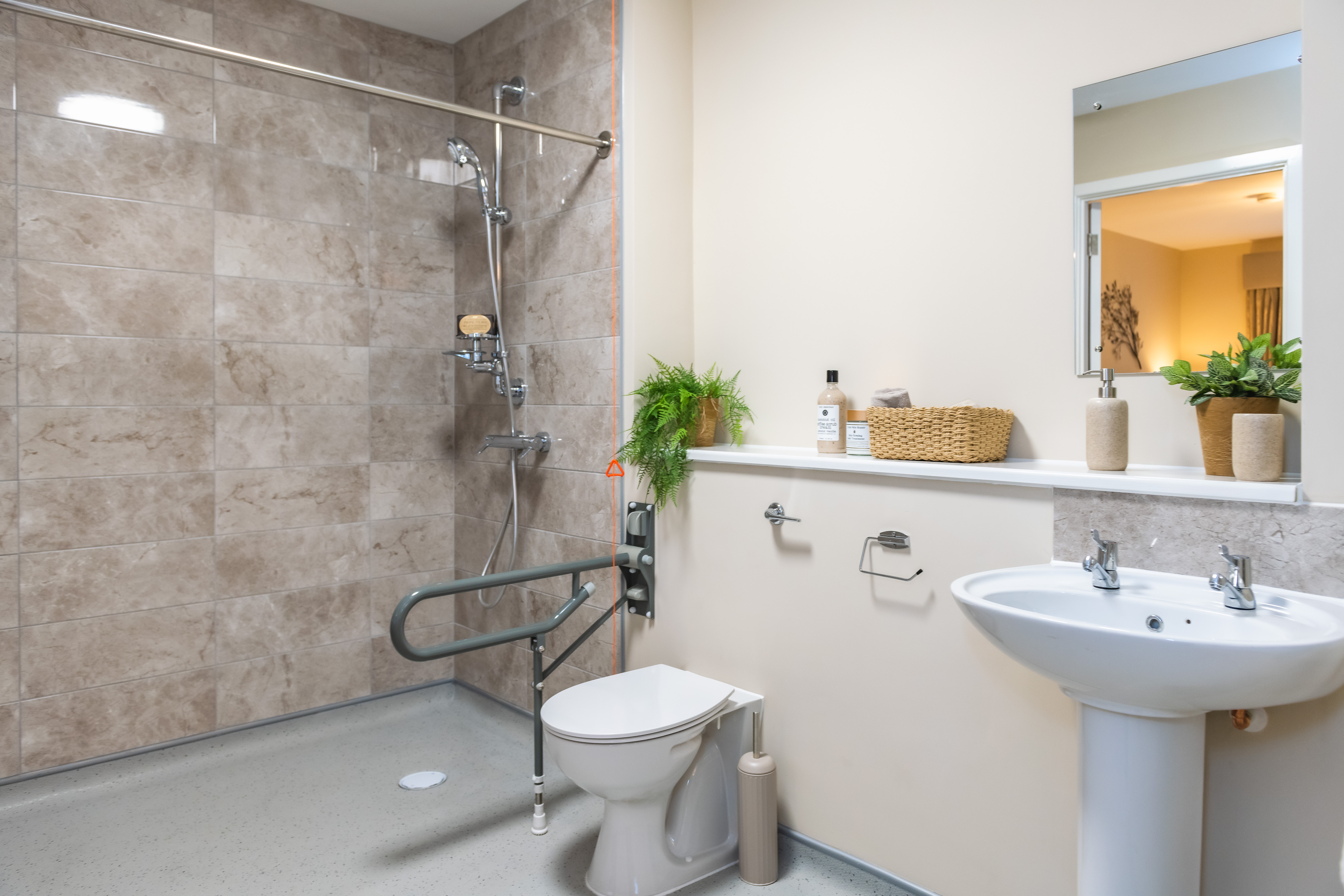 The dark tiles in the walk-in shower contrast with the lighter walls to help provide depth and give visual reference for those who are visually impaired.