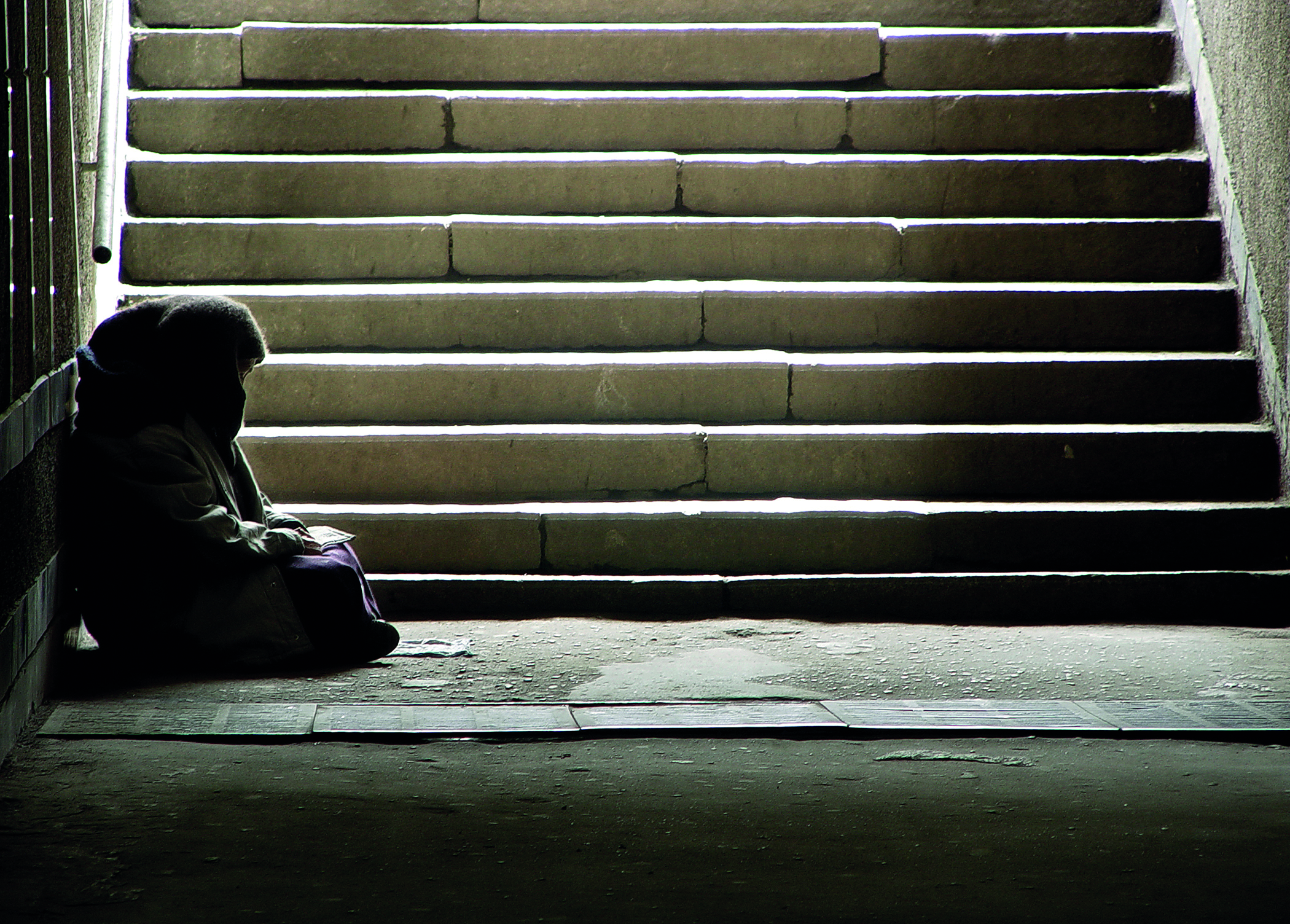 Homeless man sitting on steps