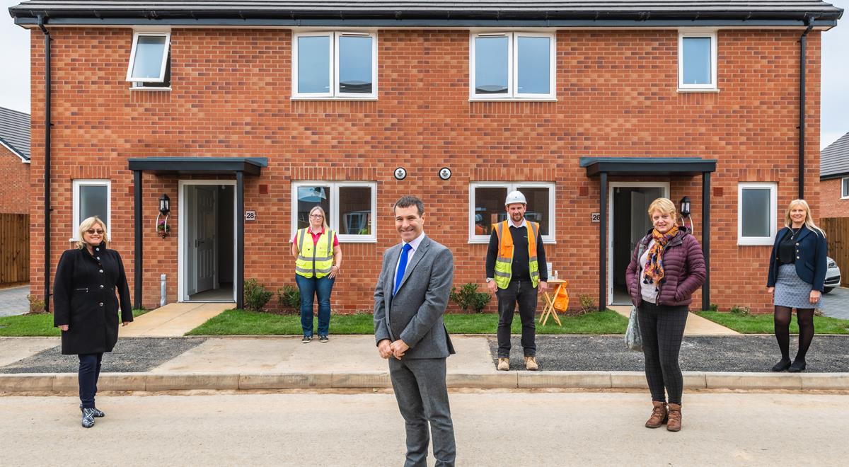 Photo of people stood outside new accessible houses