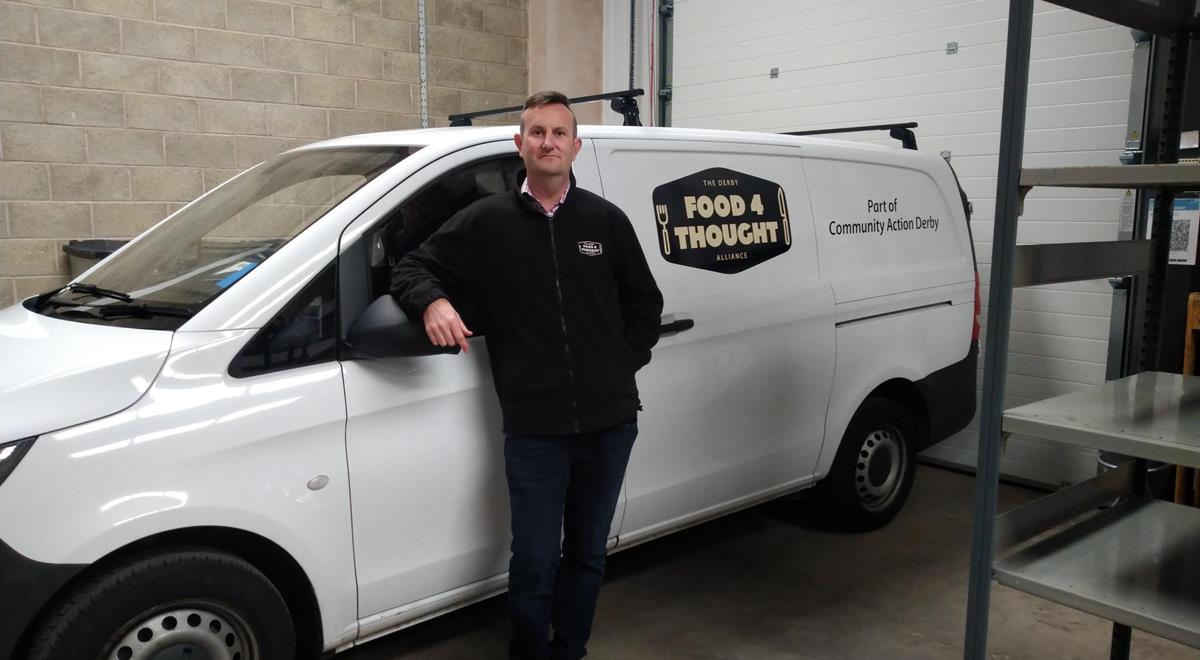 Man stood in front of a van that says 'Food 4 Thought'