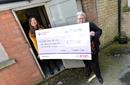 Two ladies holding a cheque for carers support NE Lincs