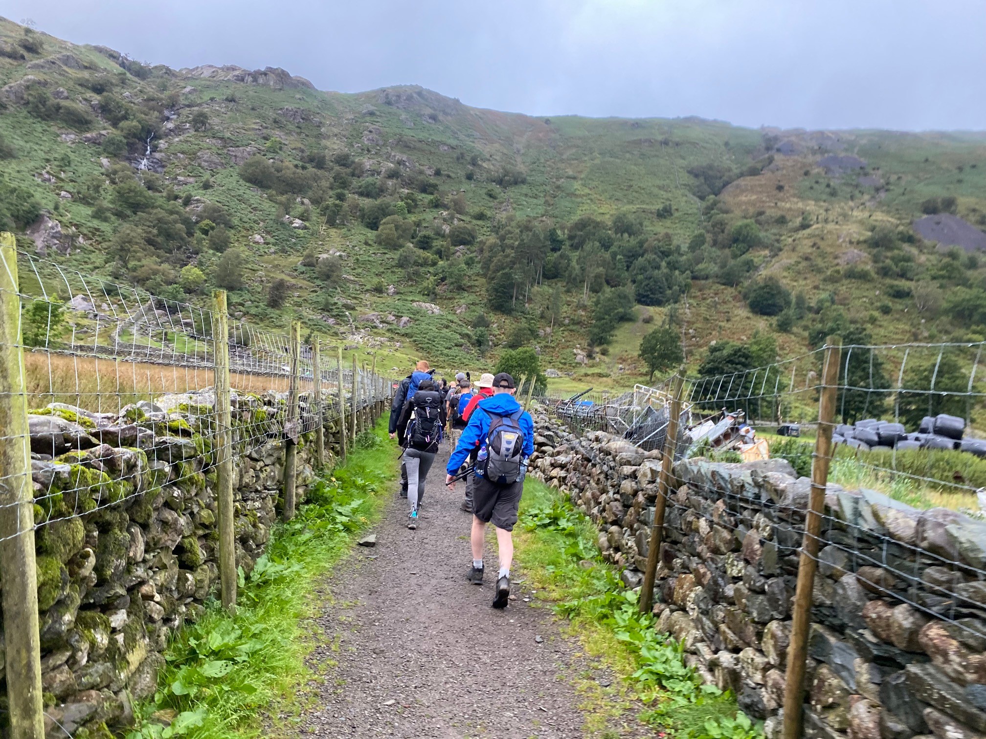 Group walking along a path by a mountain