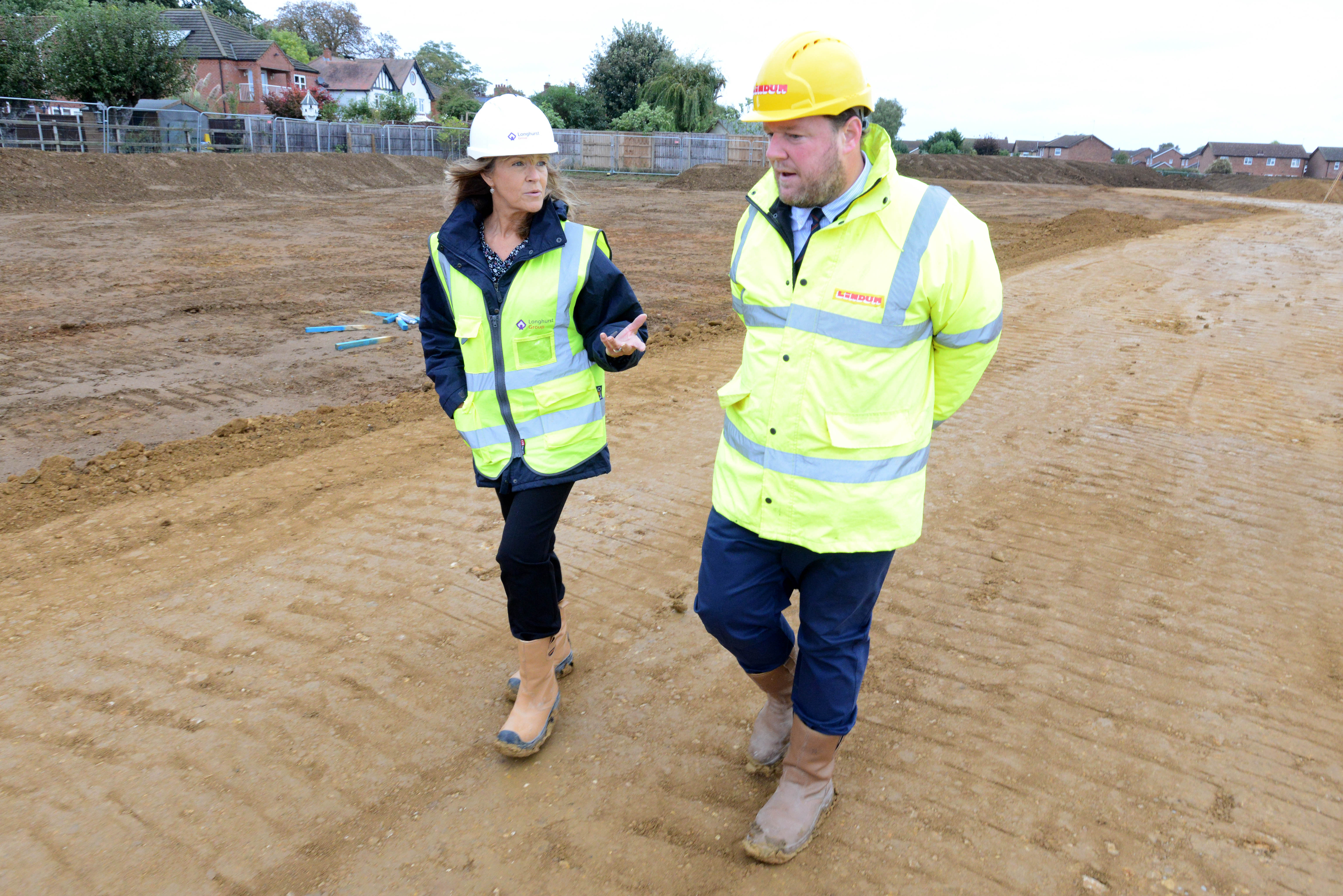 Two people walking, wearing high-vis clothing