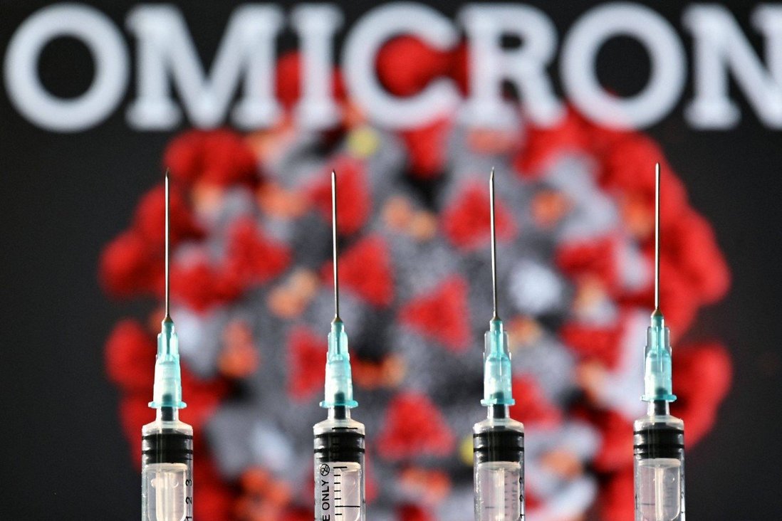Syringes pictured against an Omicron variant graphic