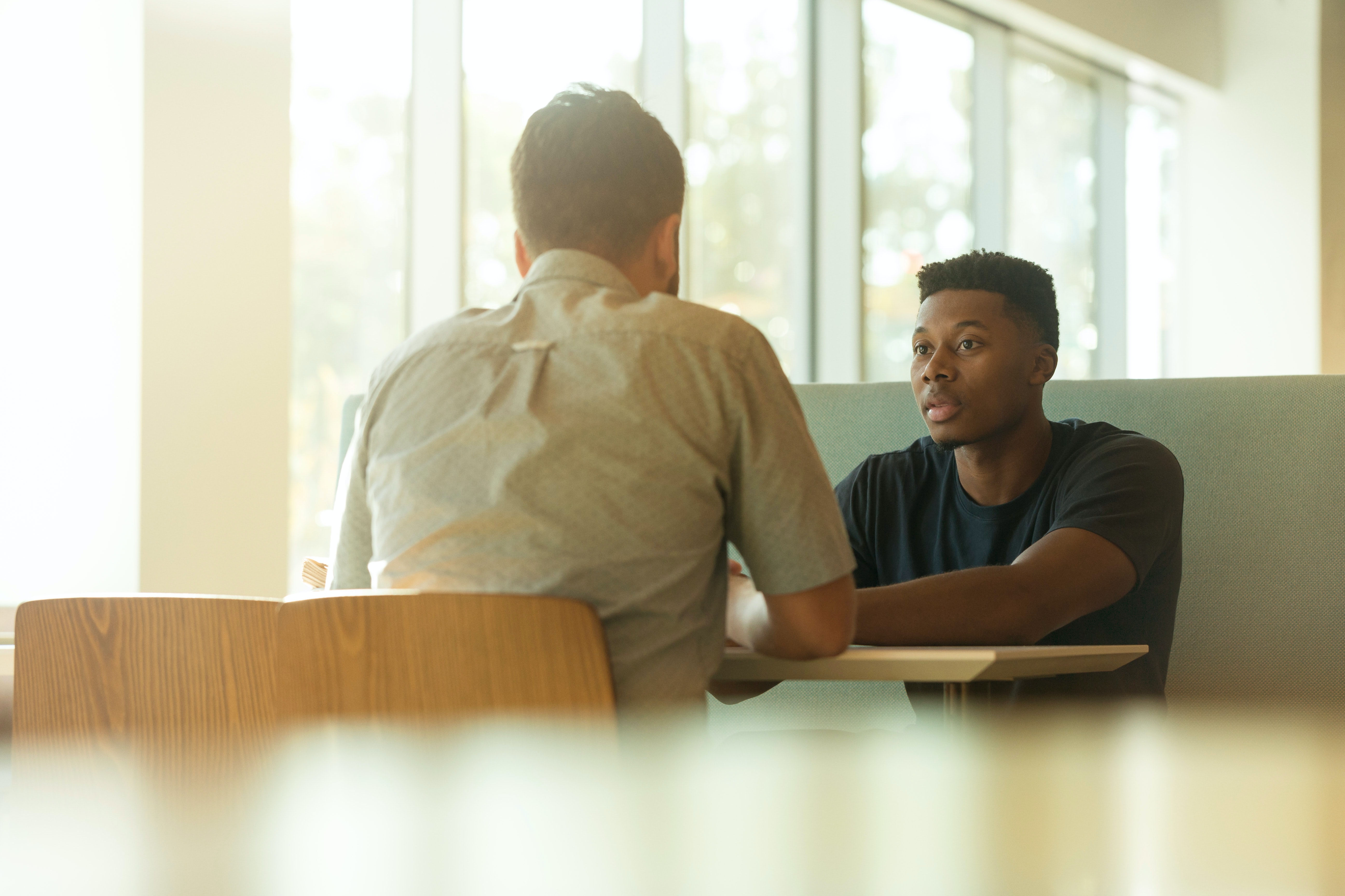 Two men talking, sat at the table