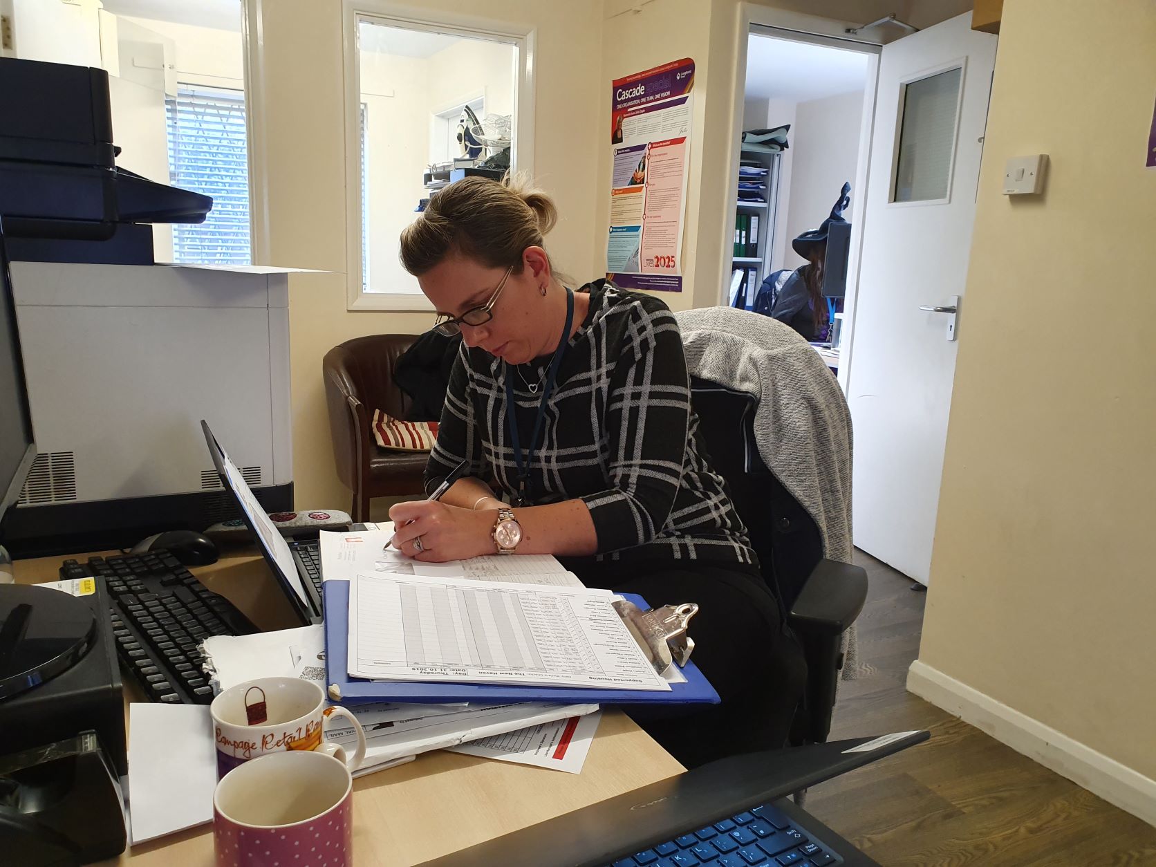 Fay sitting at a desk filling out paperwork