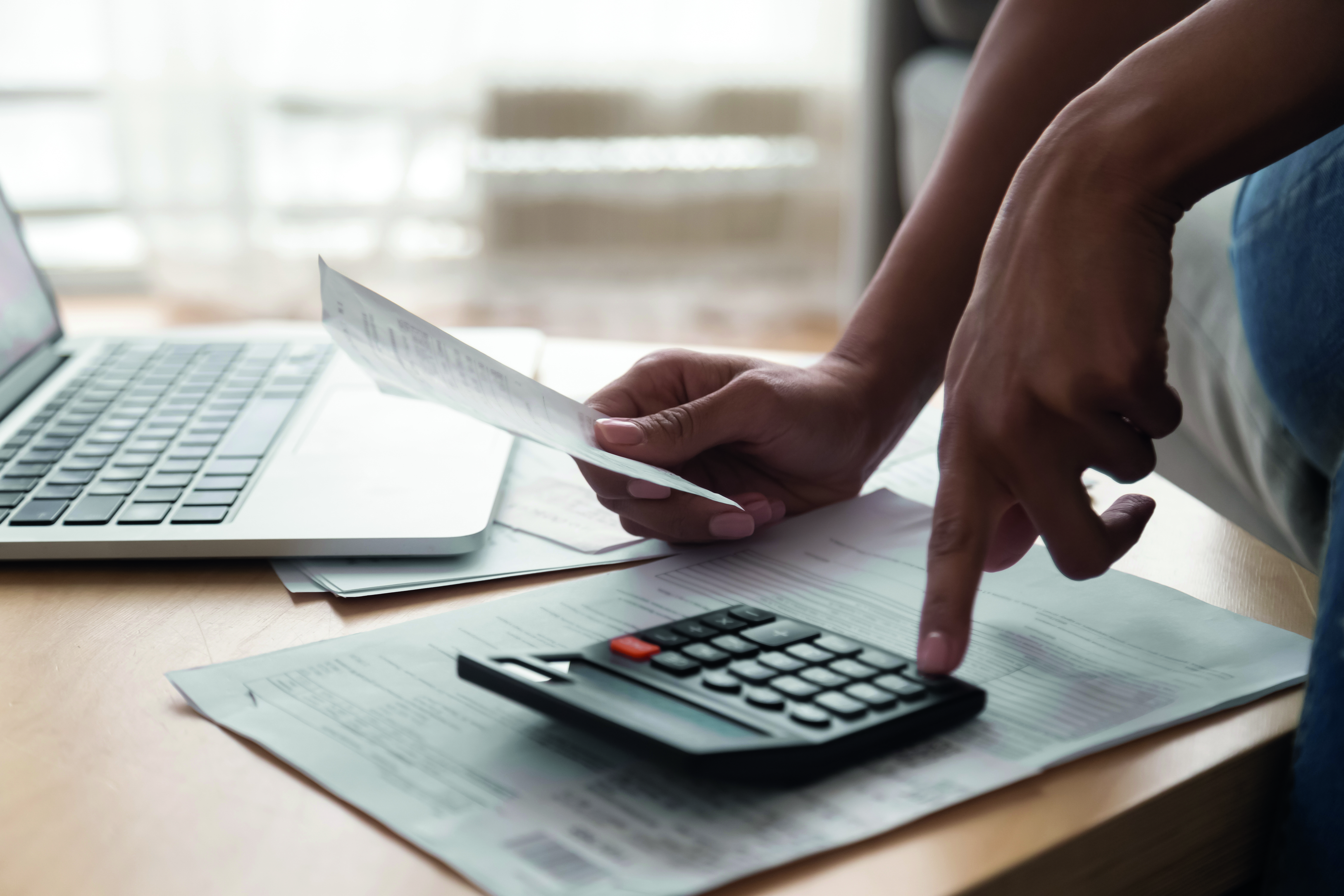 calculator and documents near a laptop