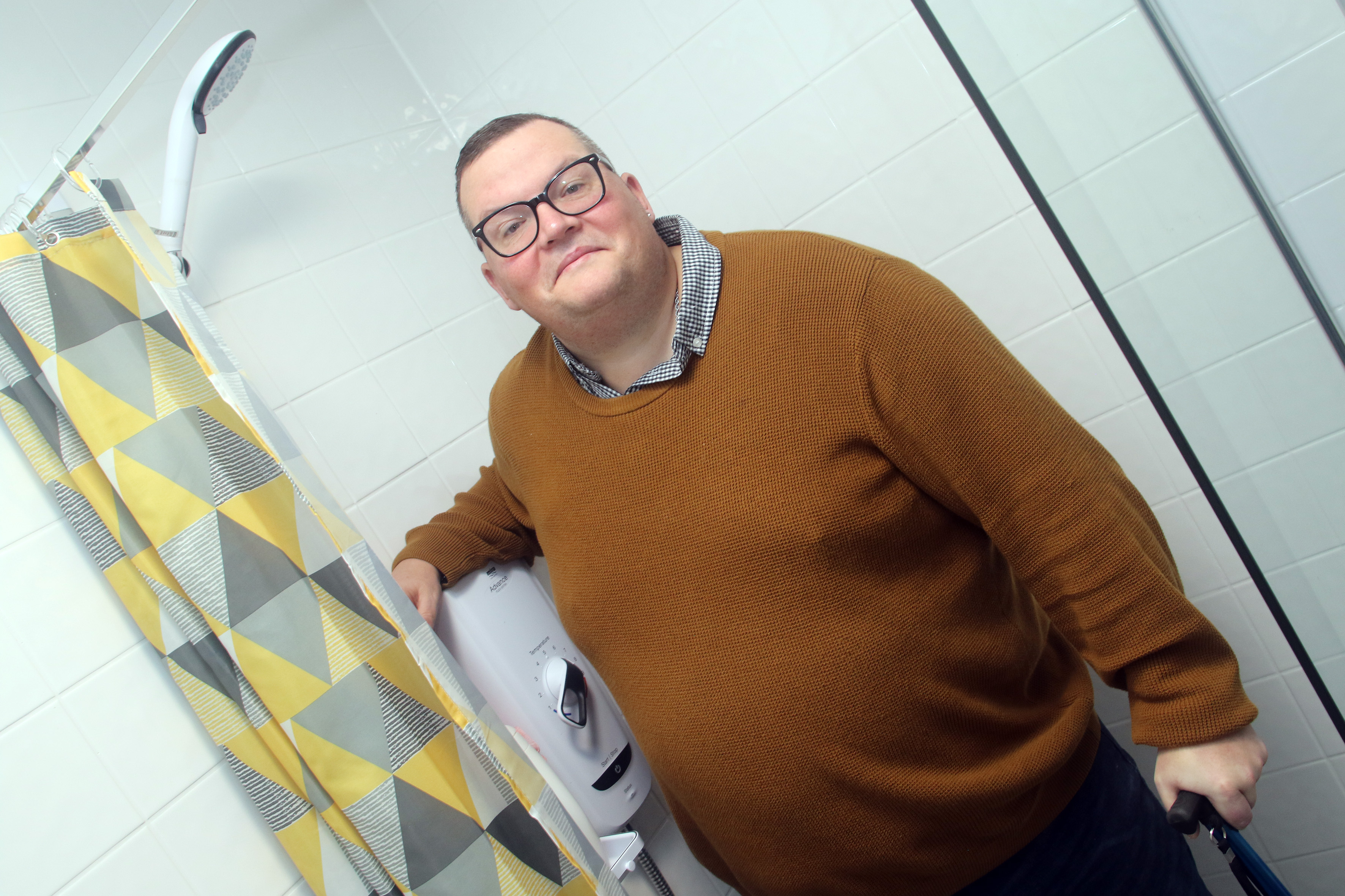 Man standing in adapted shower