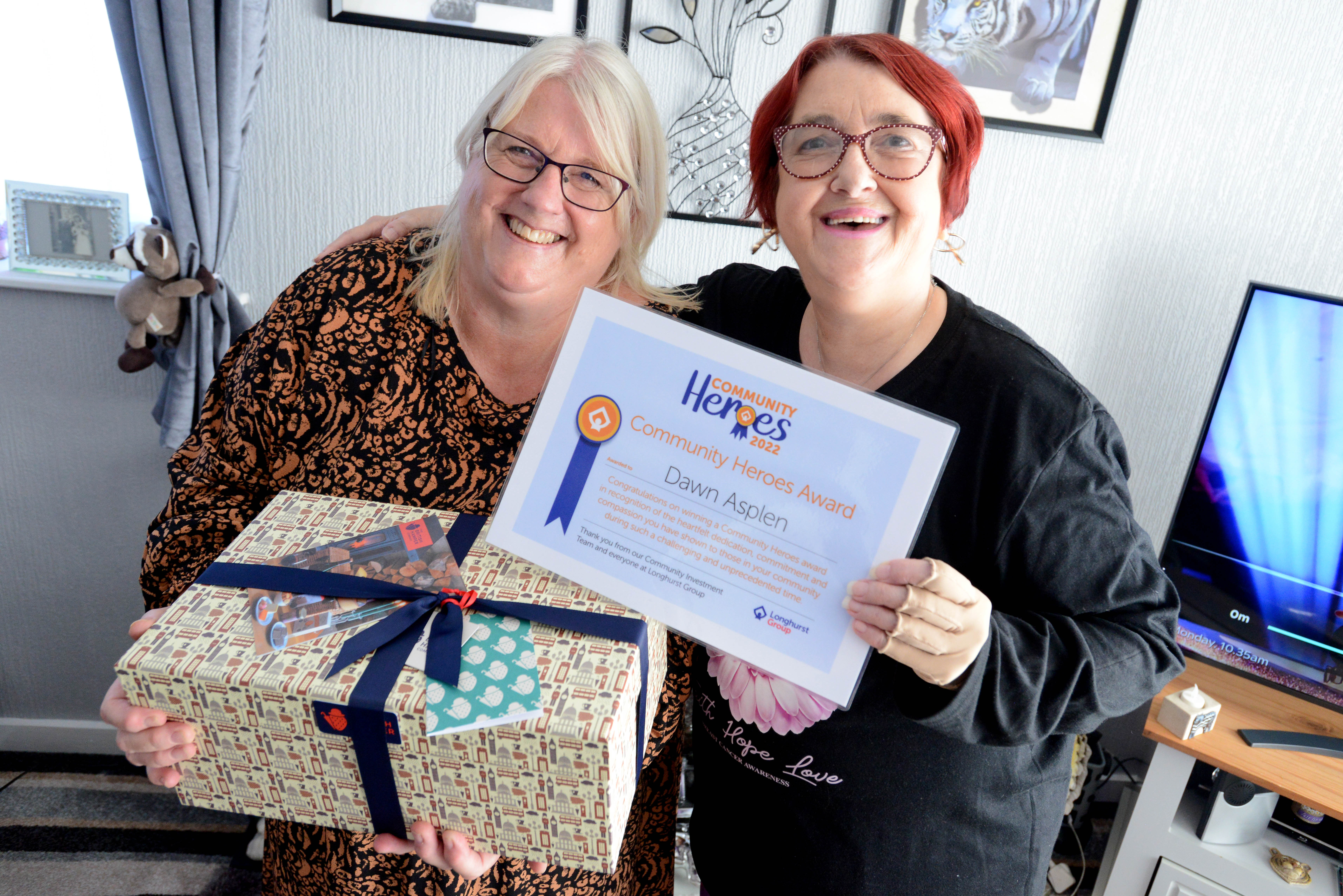 Two ladies smiling with box and certificate