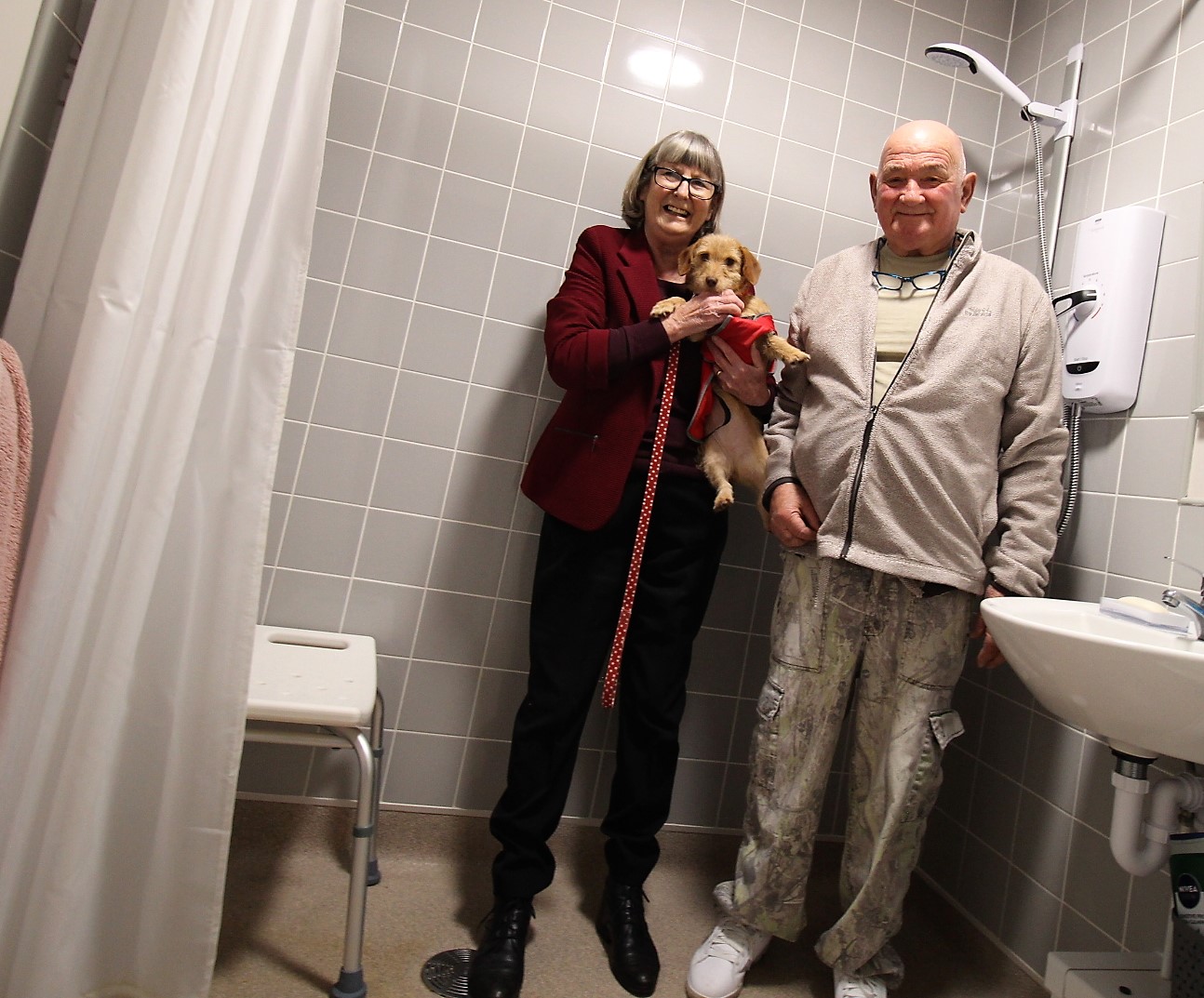 man, woman and a dog in bathroom