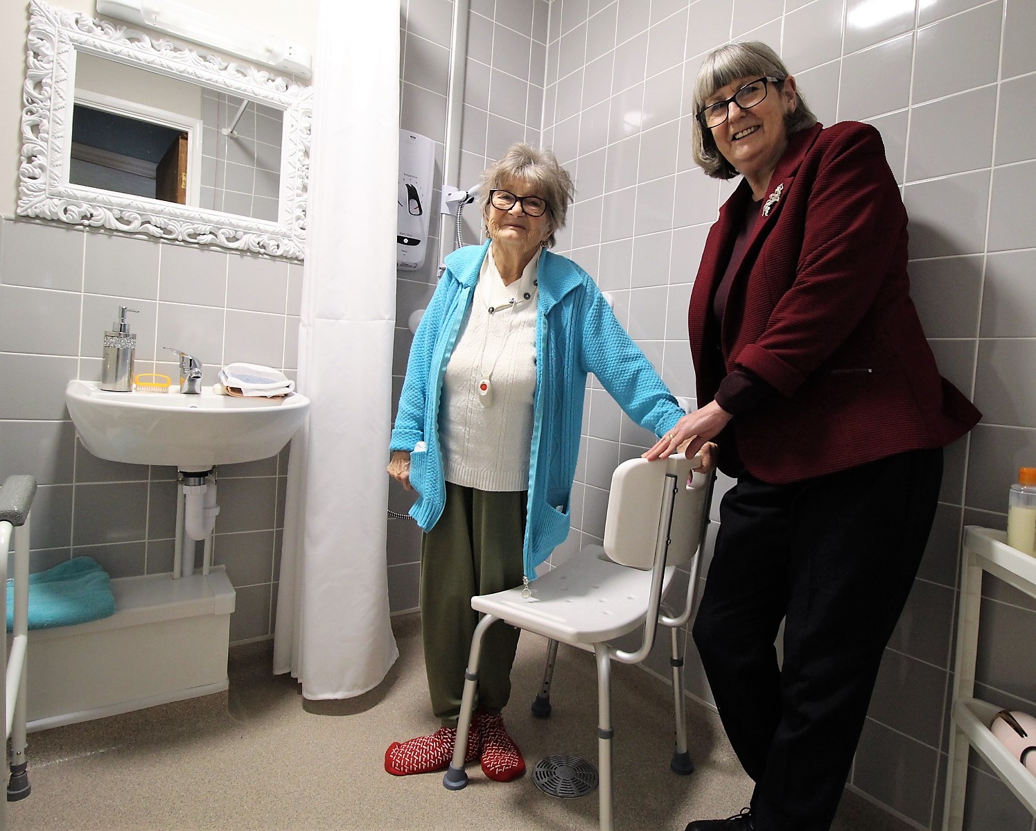 Two ladies smiling in the bathroom