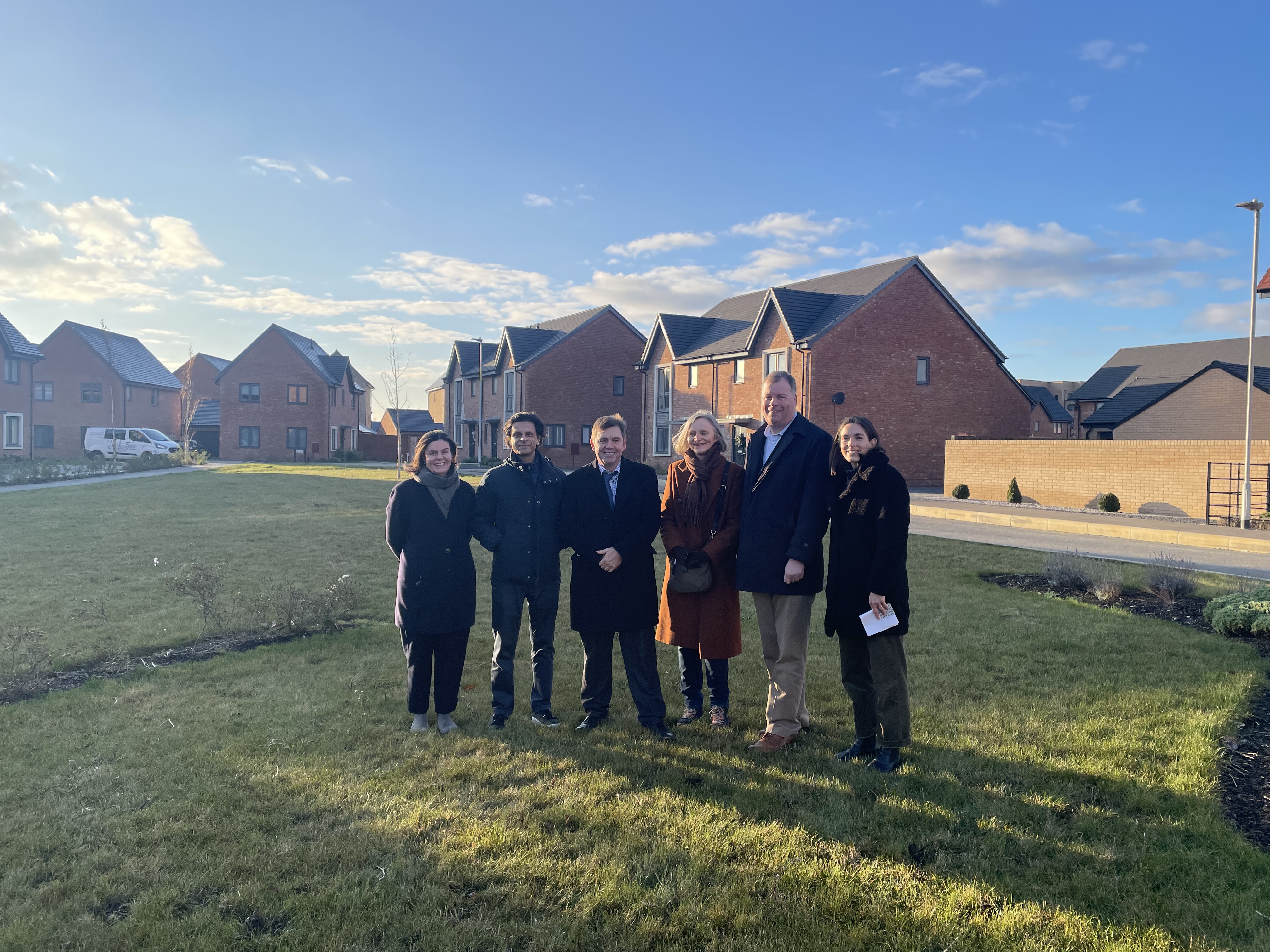 Group of people stood outside new homes