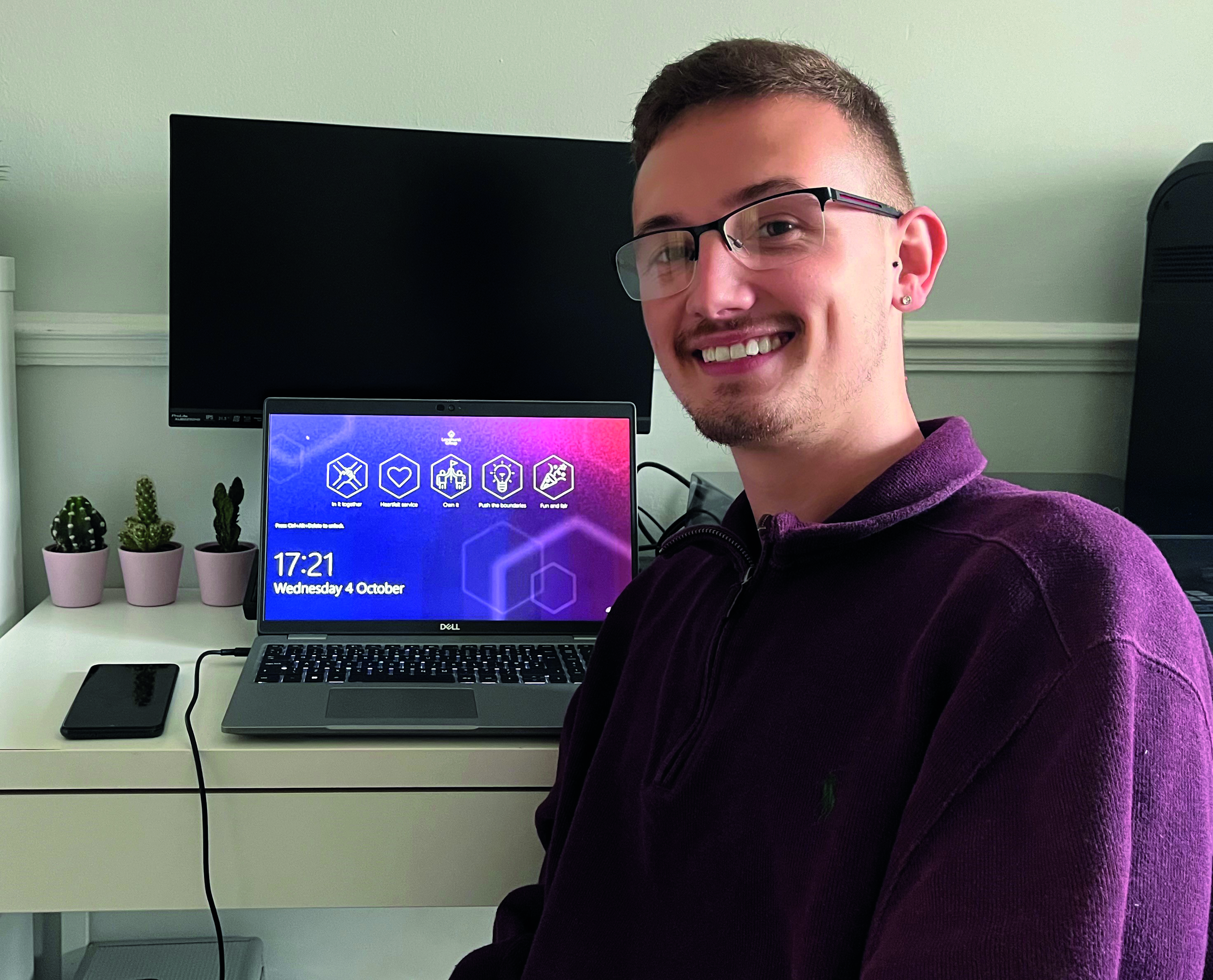 Man smiling next to a laptop