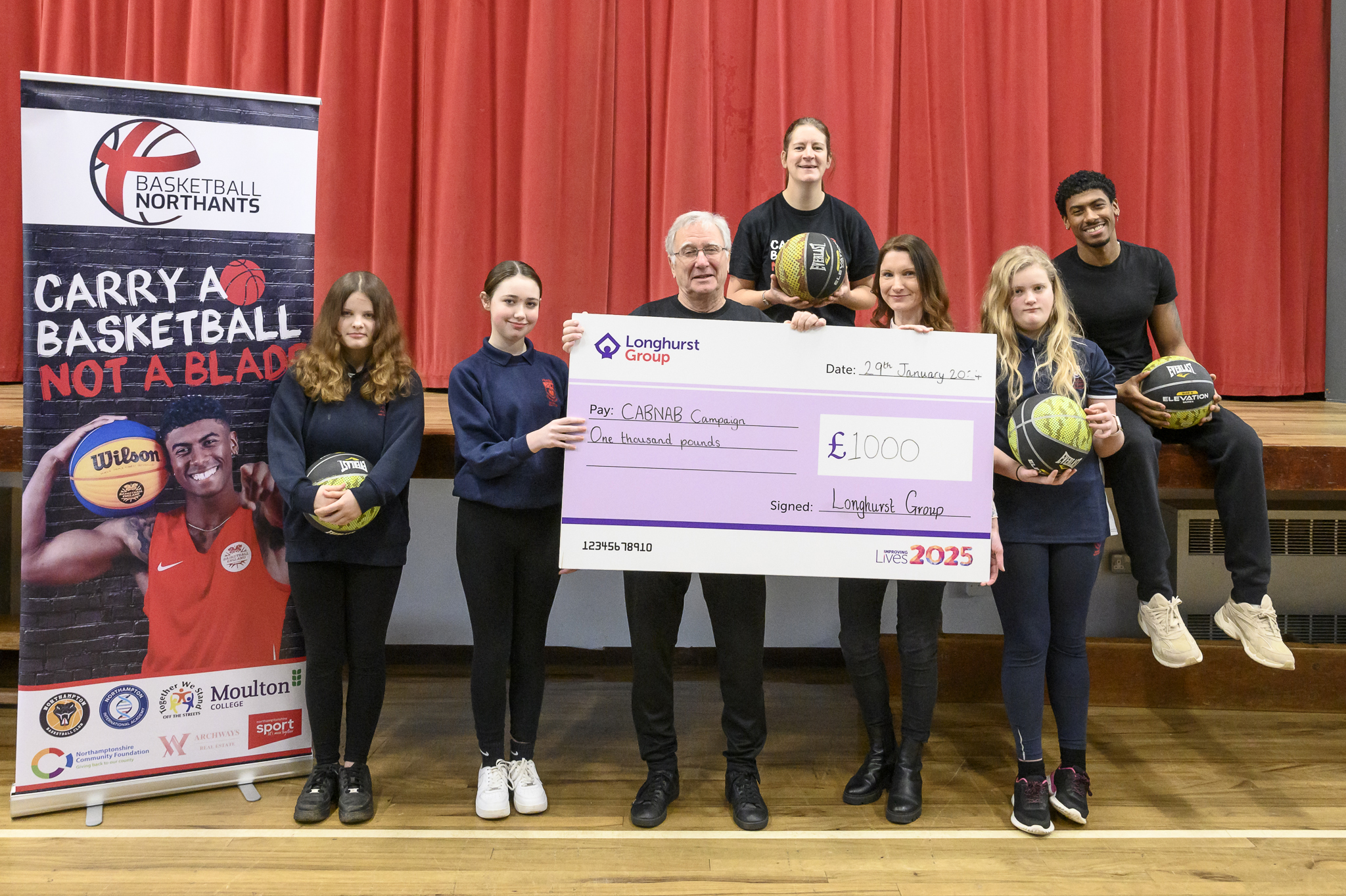 Group of people holding a large cheque