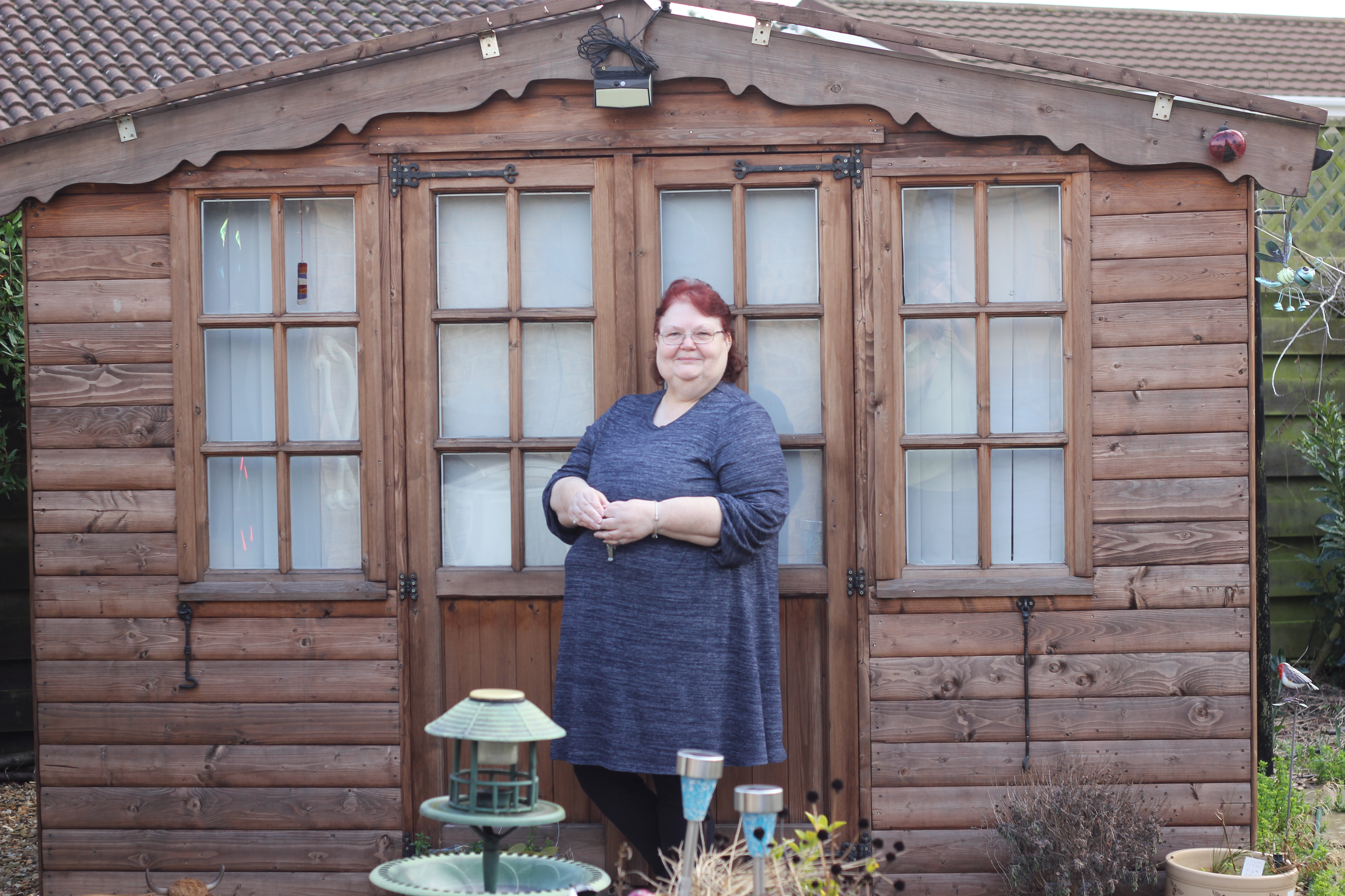 Angie smiles as she poses outside of her office shed