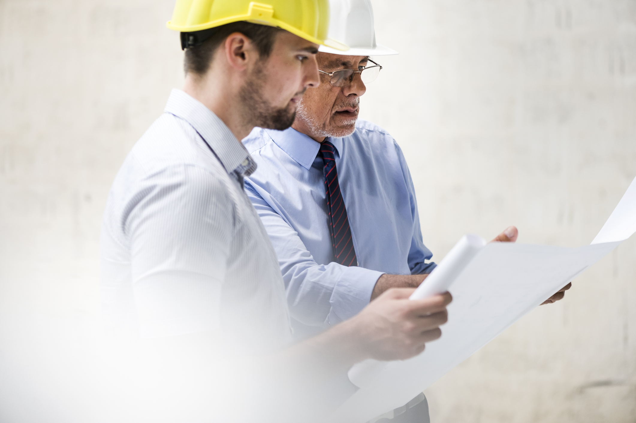 Office workers wear hardhats as they plan building changes