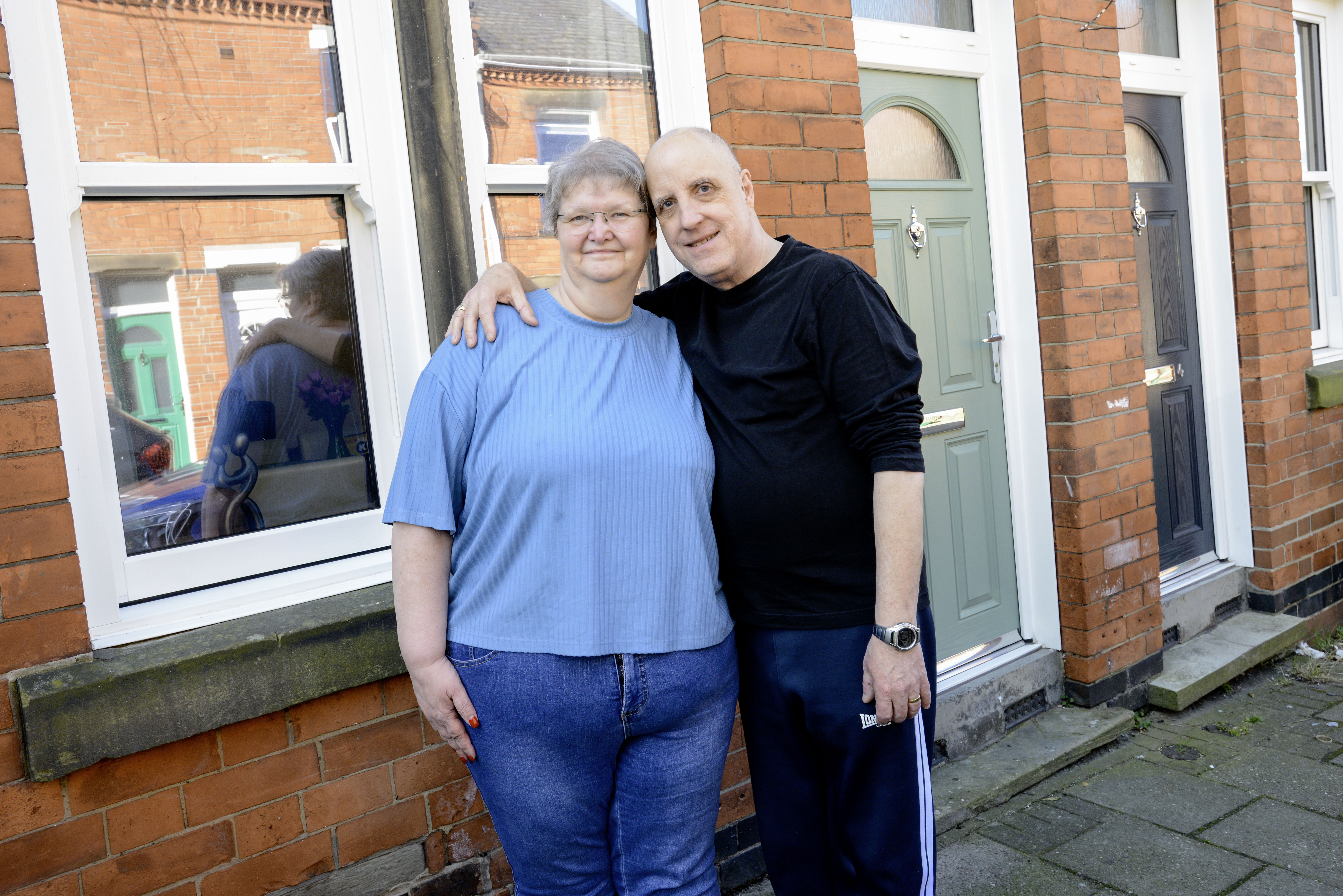 Couple stood outside their home