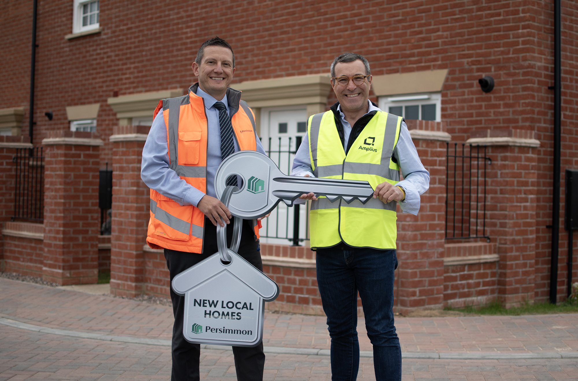 Two men smiling with a large key