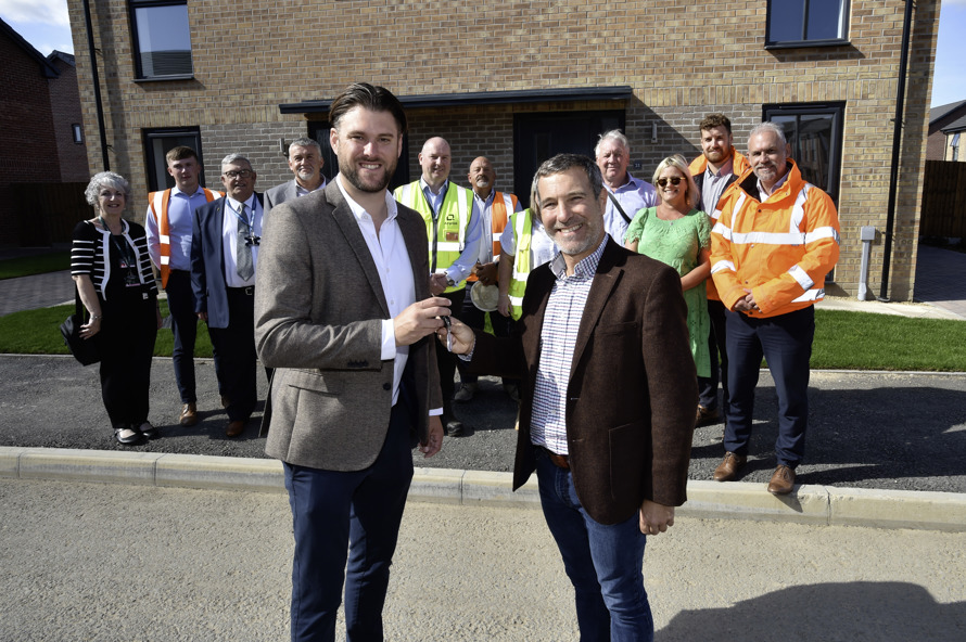 Group of people standing in front of new build homes